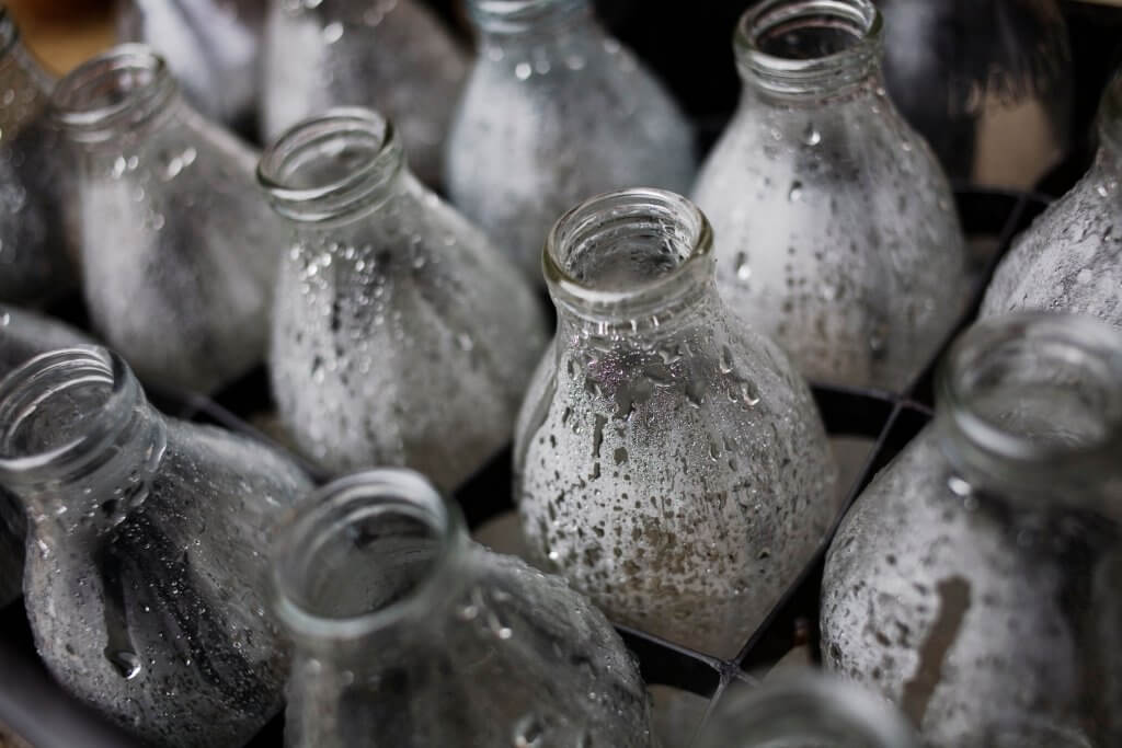 Empty glass milk bottles, plastic pollution