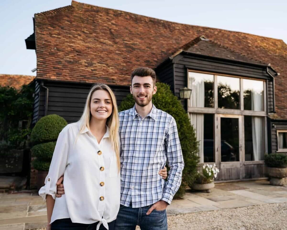 Young couple in front of barn conversion made possible through an Ecology Conversion mortgage