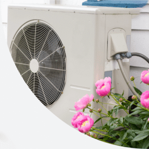 A heat pump with pink flowers to the side