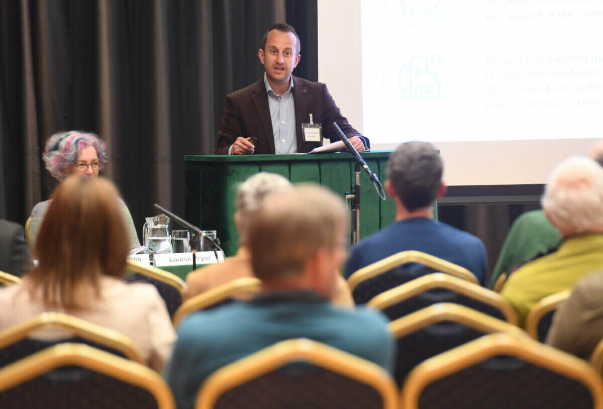 Man at a podium speaking to a crowd